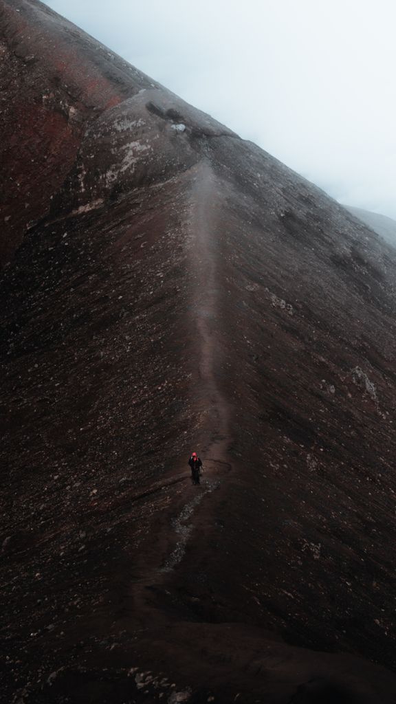 A lone hiker on a misty mountain trail in Indonesia, capturing the essence of adventure.