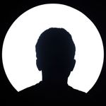 Artistic silhouette of an unknown person against a bright circular light background.